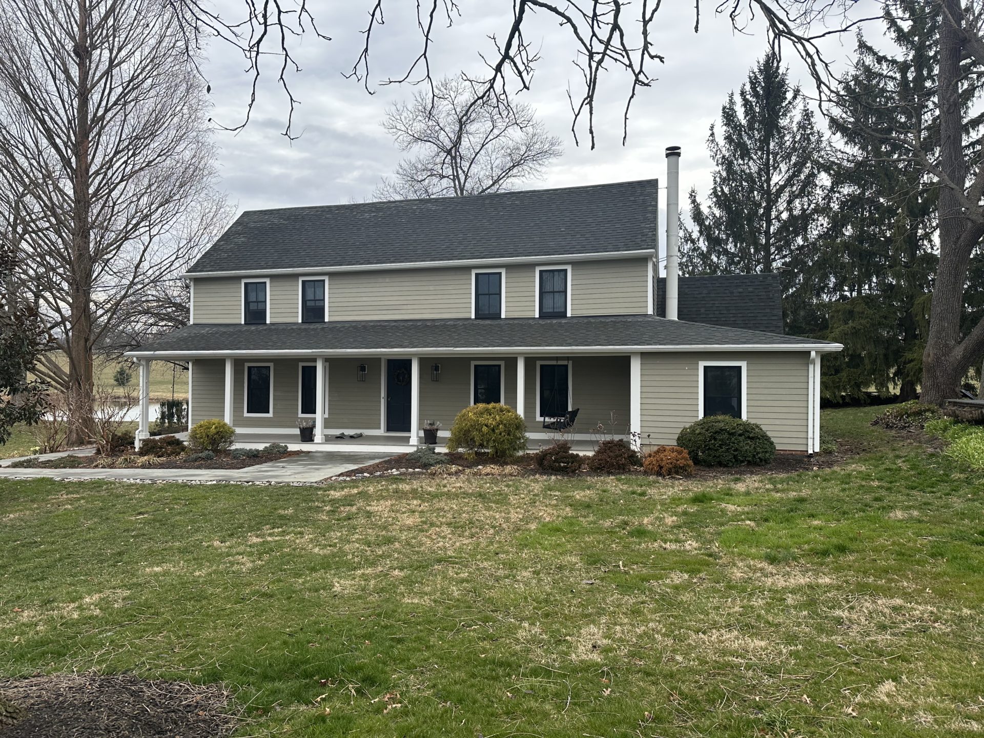 Old farmhouse in Woodbine, MD, with weathered siding and black windows, before painting.